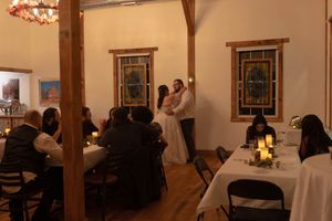 Wedding reception venue with wooden accents and stained glass windows.