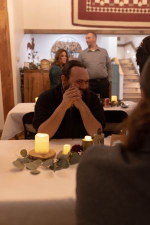 Wedding reception guests seated at tables with glowing candle centerpieces.