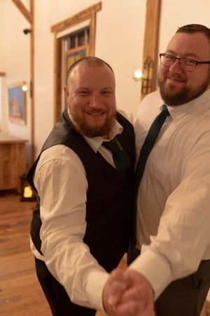 Two people dancing and laughing together at a wedding reception.