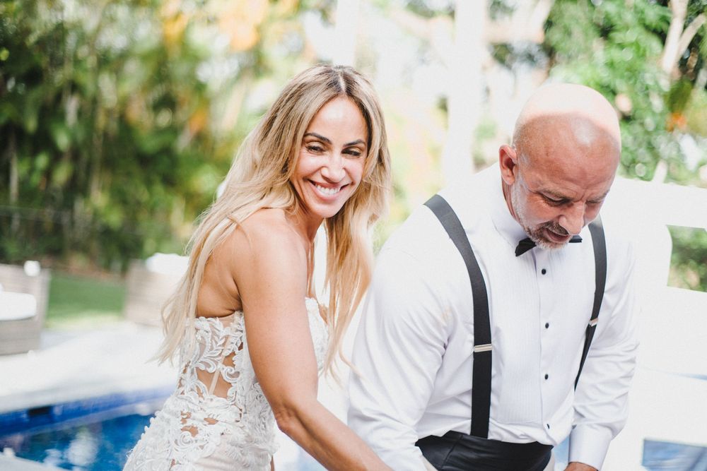 A bride and groom share intimate moments during their outdoor wedding photoshoot in a garden setting.