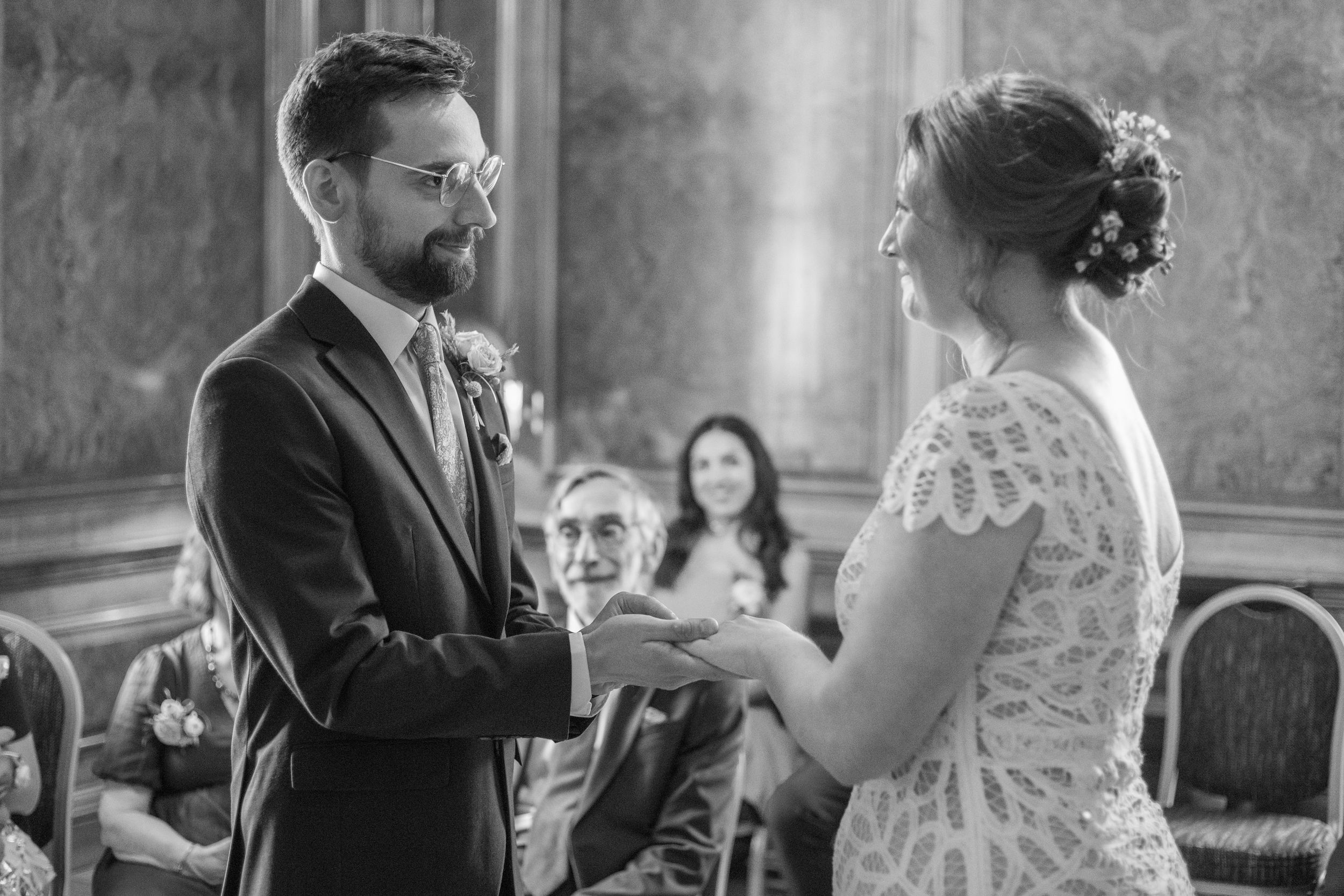 Wedding ceremony moments captured in black and white showing intimate exchanges between the couple.