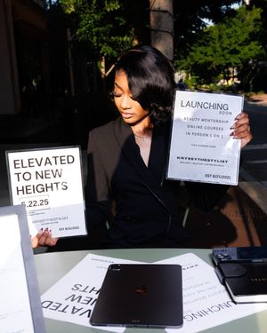 Professional models display signs with text during a fashion show presentation in a dimly lit setting.