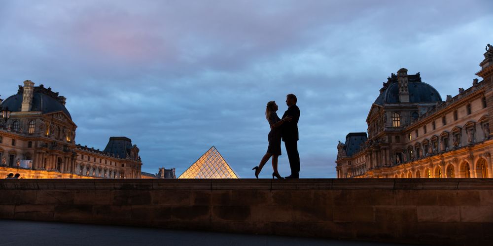 Couple silhouetted beside the Louvre in Paris