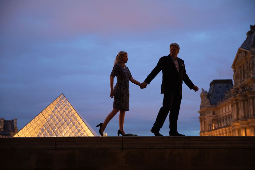 Striking shot of couple in pose silhouetted against The Louvre in Paris