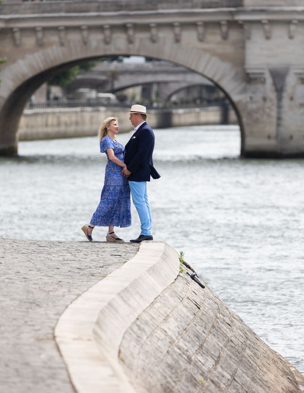 Couple in embrace beside city riverbank
