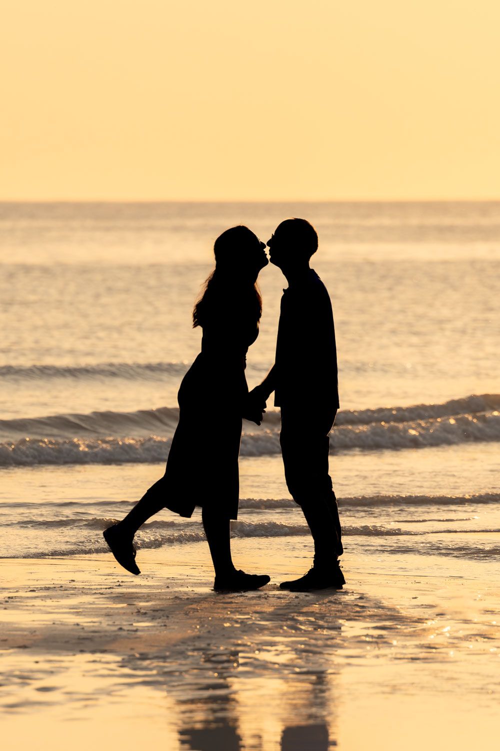 Silhouette of couple on beach at sunset at East Sussex | Birling Gap