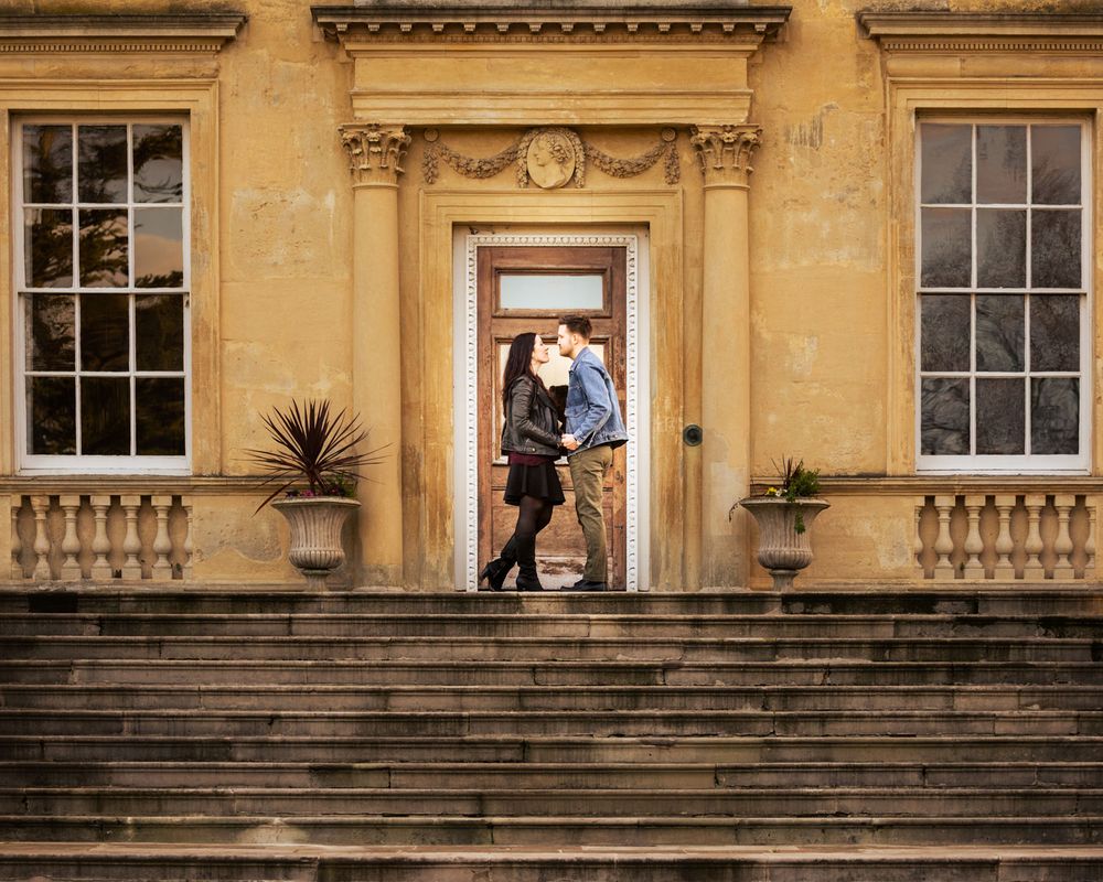 Couple embrace framed by doorway of Kent Mansion