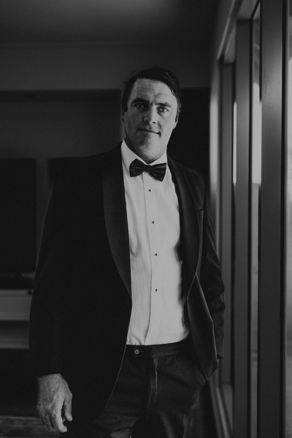 portrait shot of groom in tuxedo with natural light highlighting his features