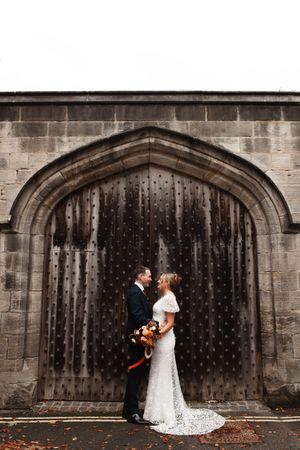 A romantic wedding couple embraces under a stone archway in a sequence of five similar photos with a rustic backdrop.