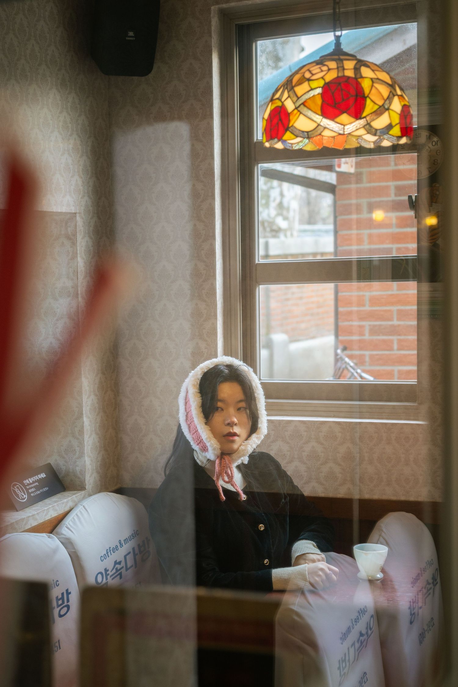 A cozy cafe interior with a decorative stained glass window and warm lighting creating an intimate atmosphere.