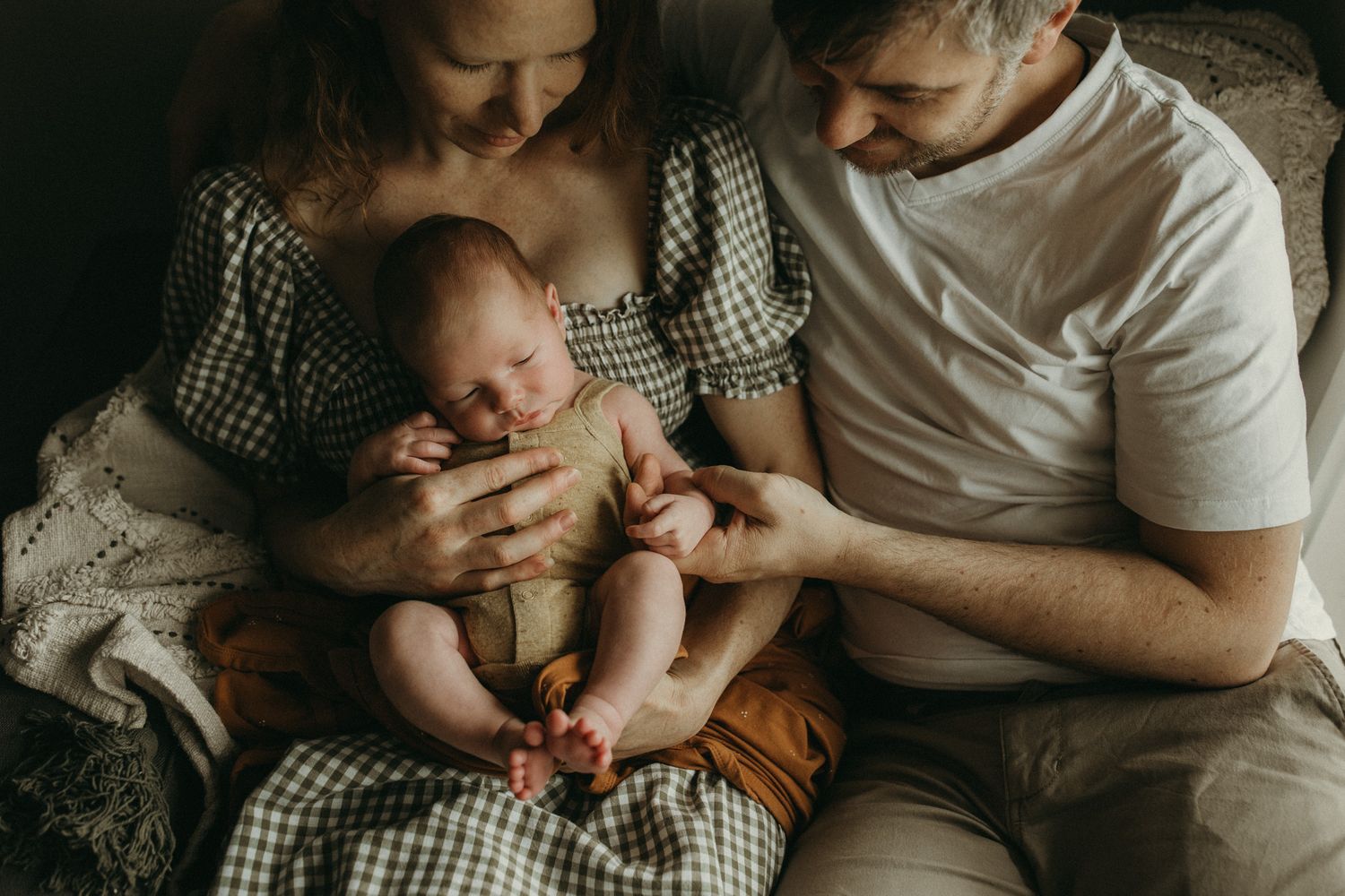 Mother and father holding newborn baby at home in Melbourne