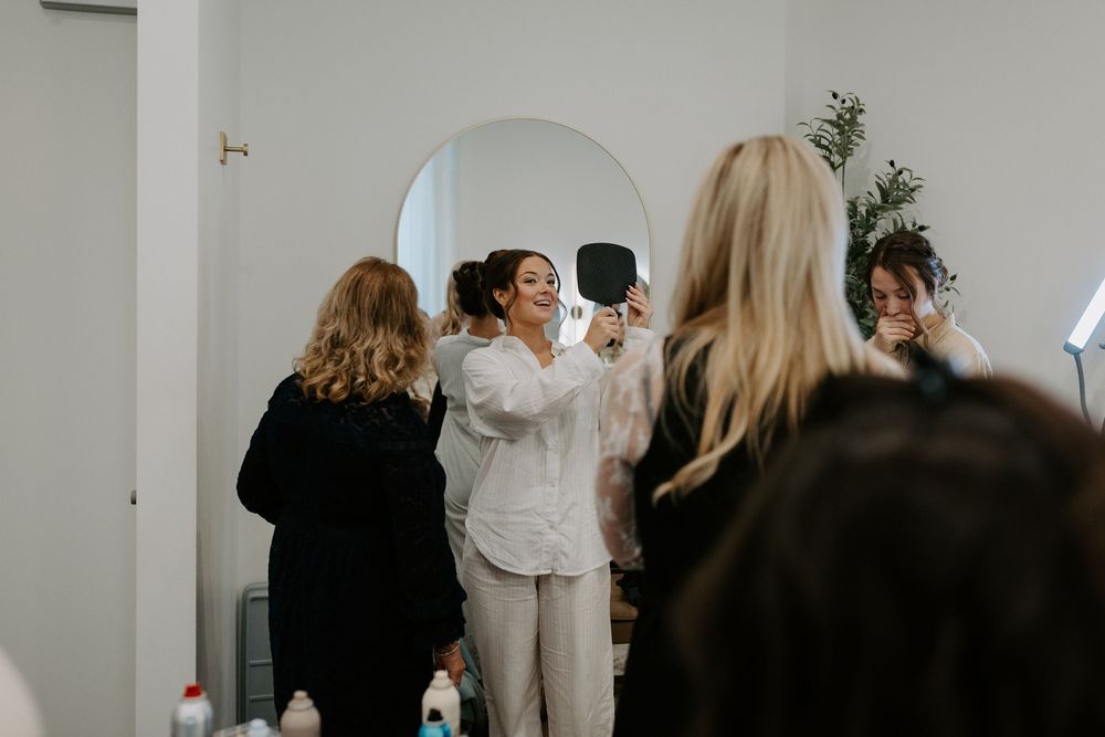 Wedding guests mingle in a modern white venue space during reception.