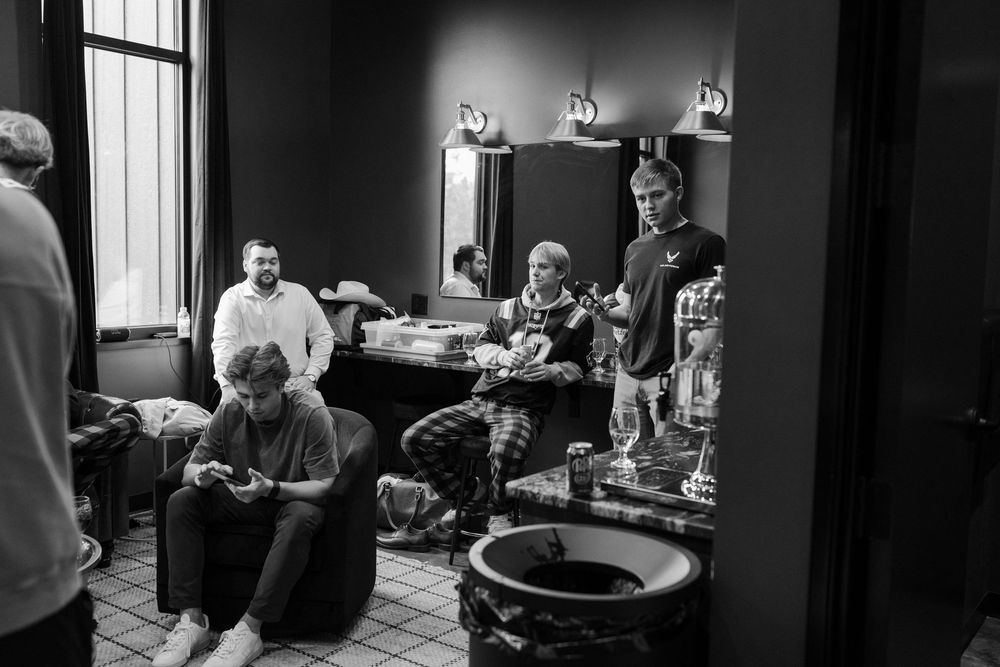 Black and white candid shots of wedding day preparations in a dark room setting.