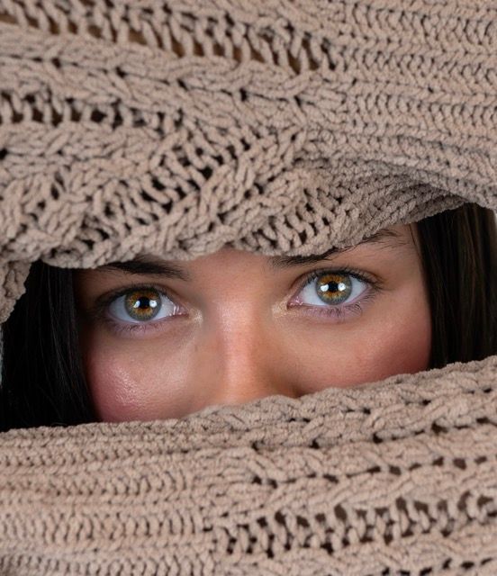 Close-up creative portrait of a woman framed by a textured knit sweater
