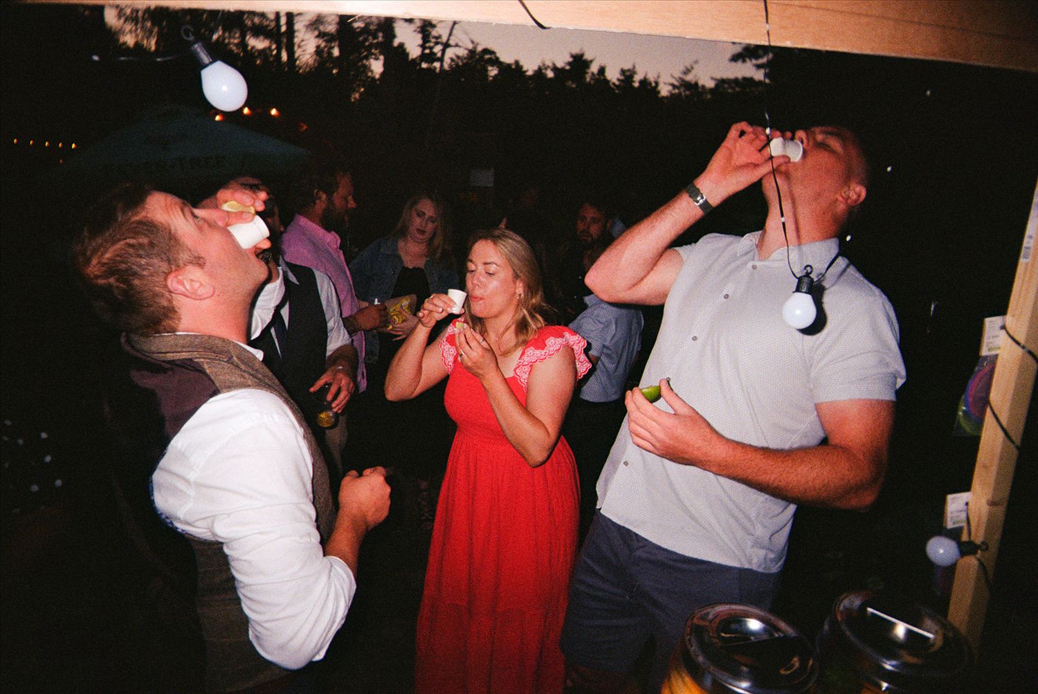 A sequence of party photos showing people dancing and drinking at a dimly lit indoor venue during a celebration.