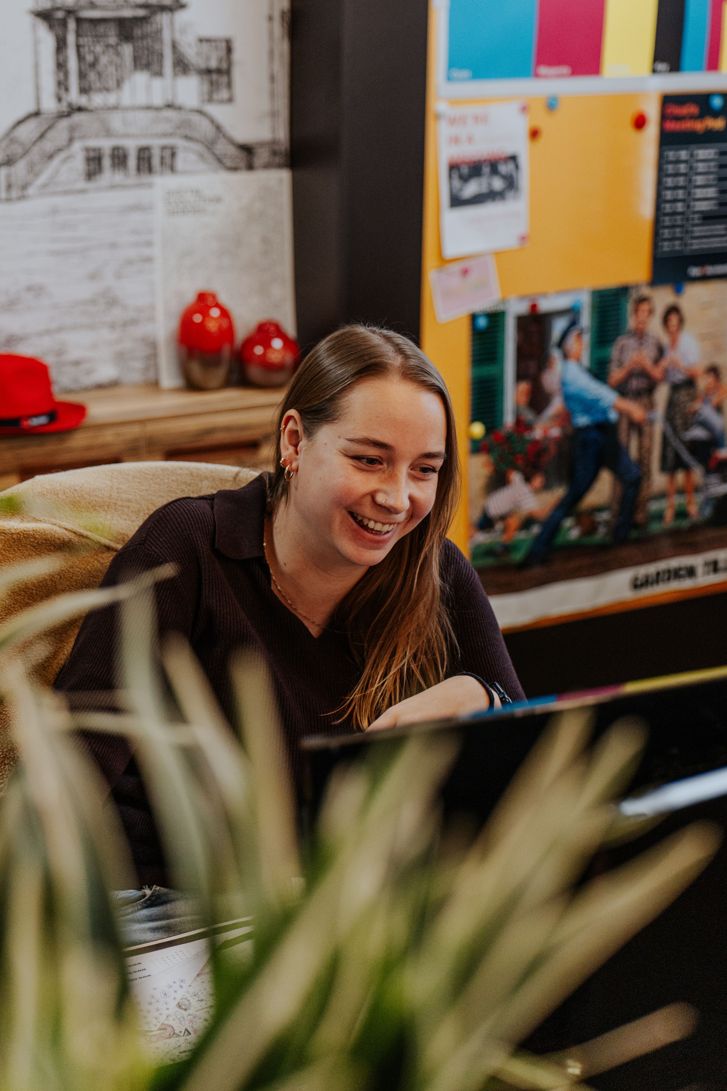 A series of candid shots showing someone laughing and smiling while sitting at a desk in a casual office environment.