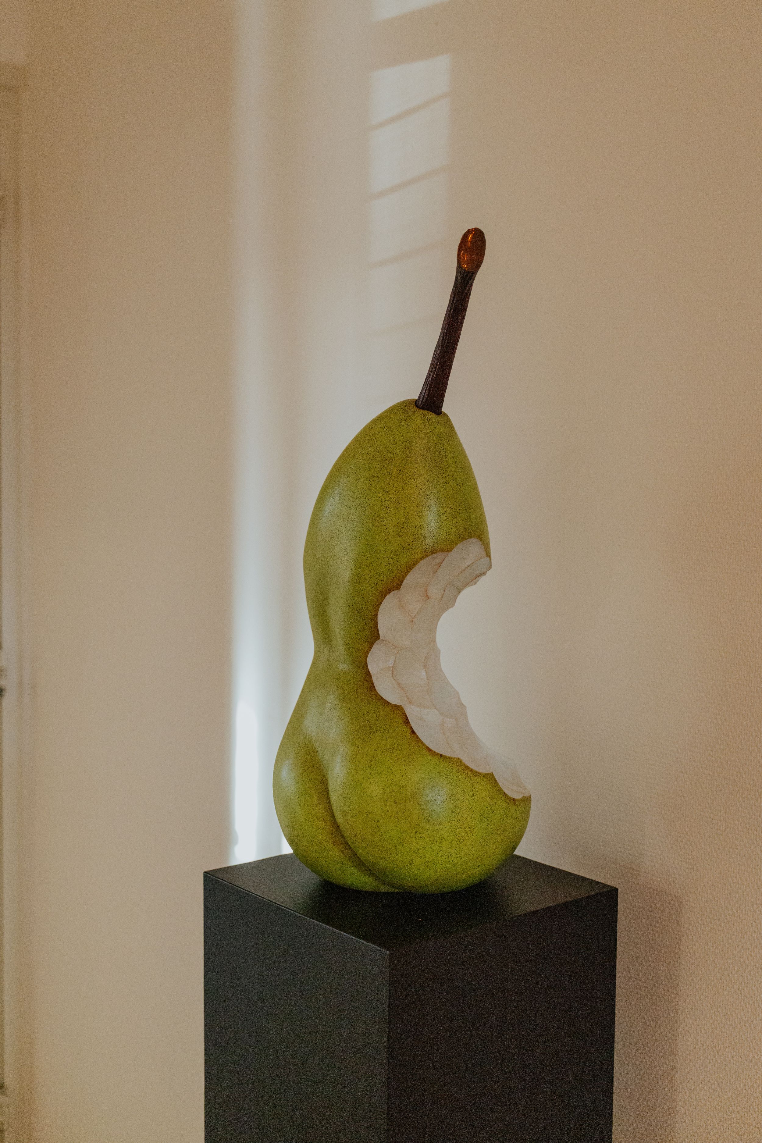 Time-lapse sequence showing a green pear being eaten in six progressive bites against a white wall background.