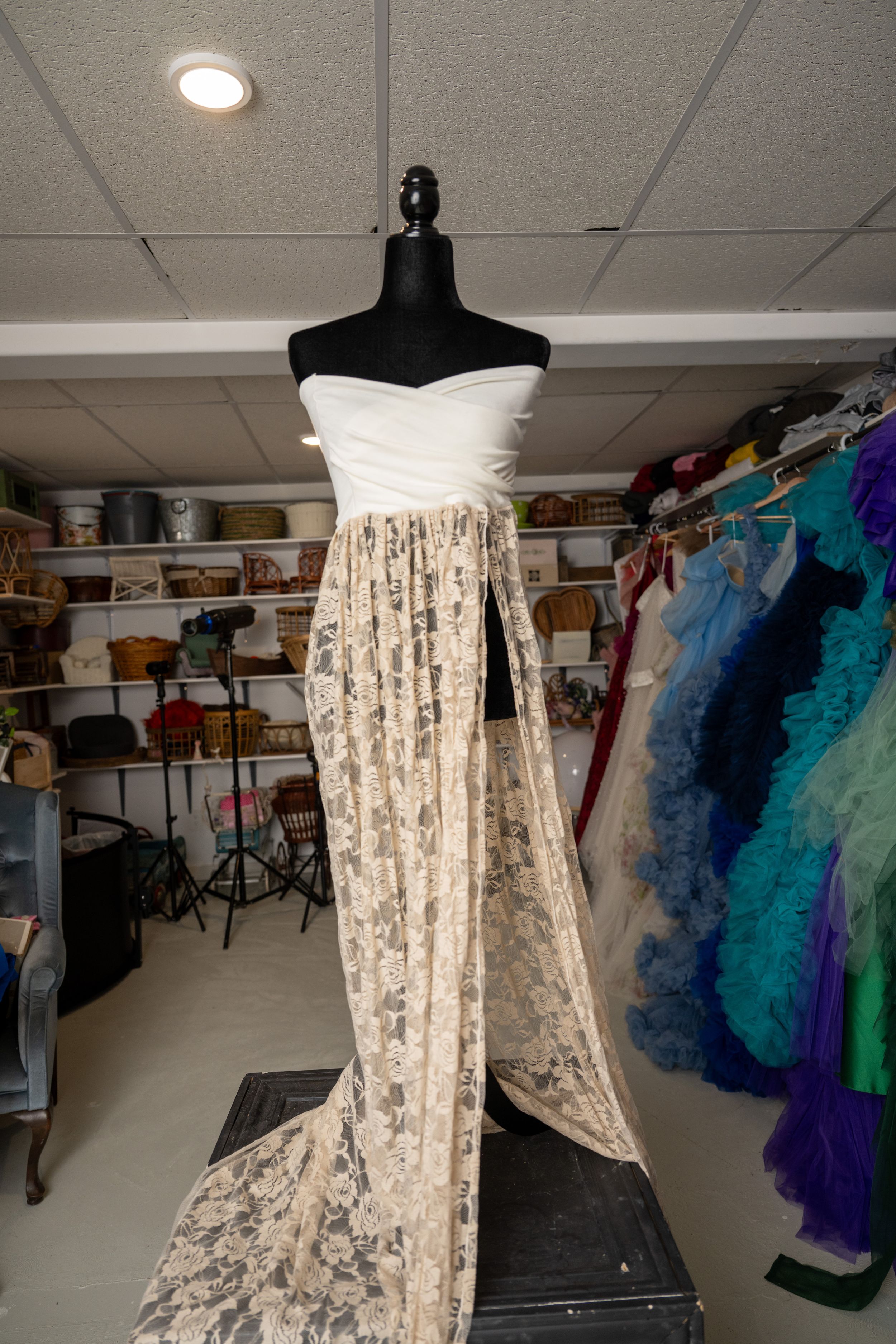 A series of photos showing a white lace dress form displayed in a studio setting with storage shelves and lighting.