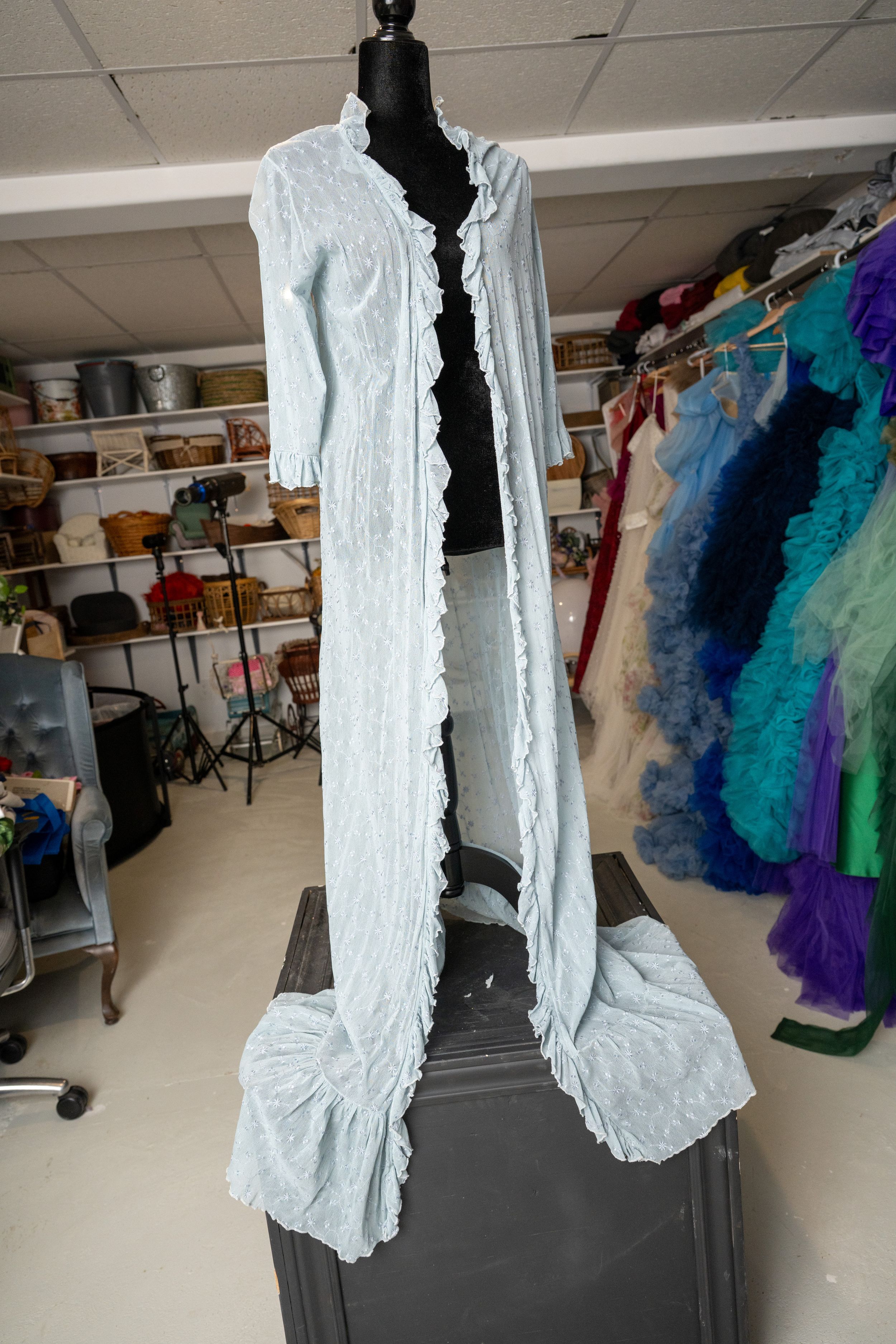 A series of photos showing a white ruffled dress displayed on a mannequin in what appears to be a costume storage room.