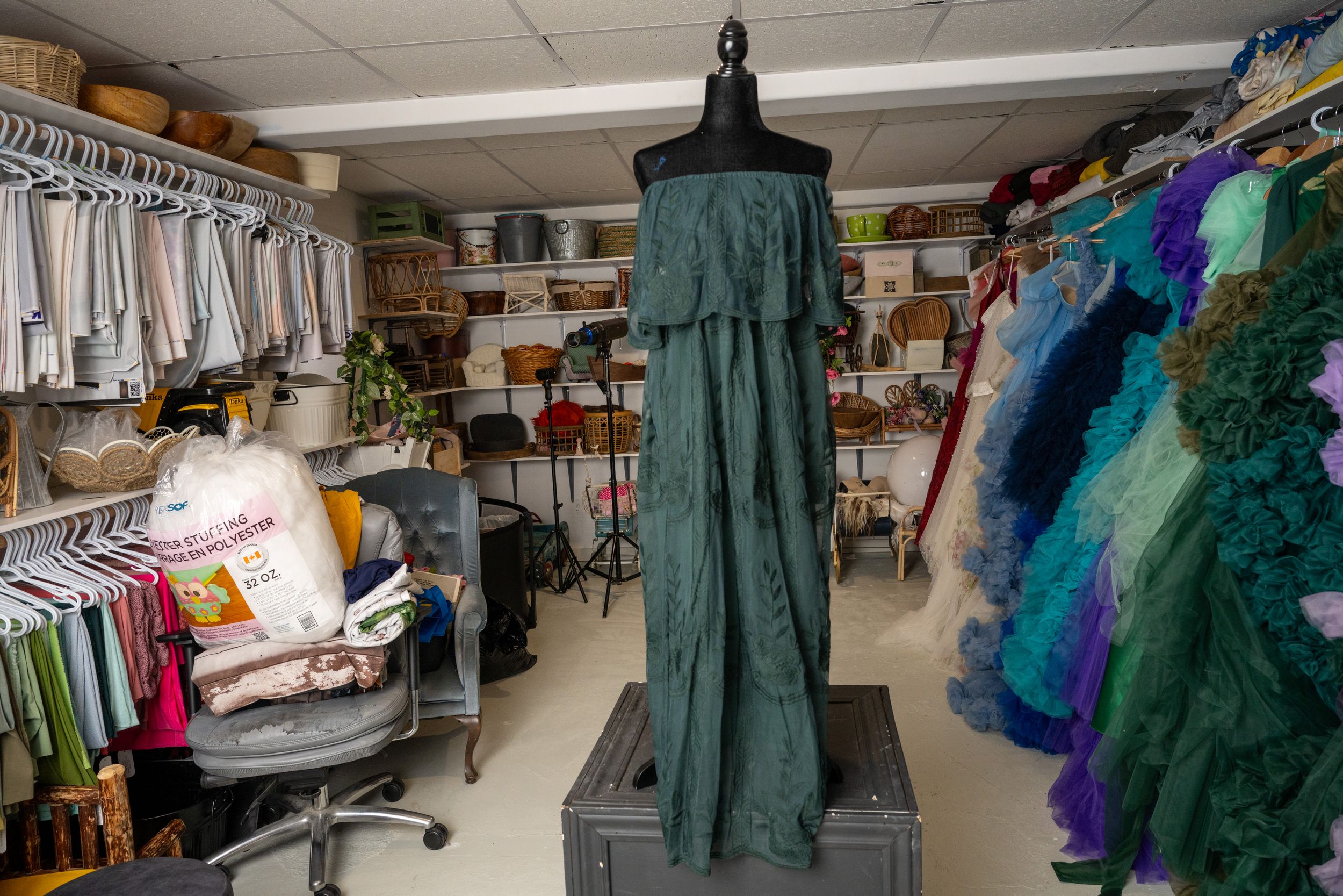 A panoramic view of a costume shop interior showing racks of colorful dresses and theatrical garments.