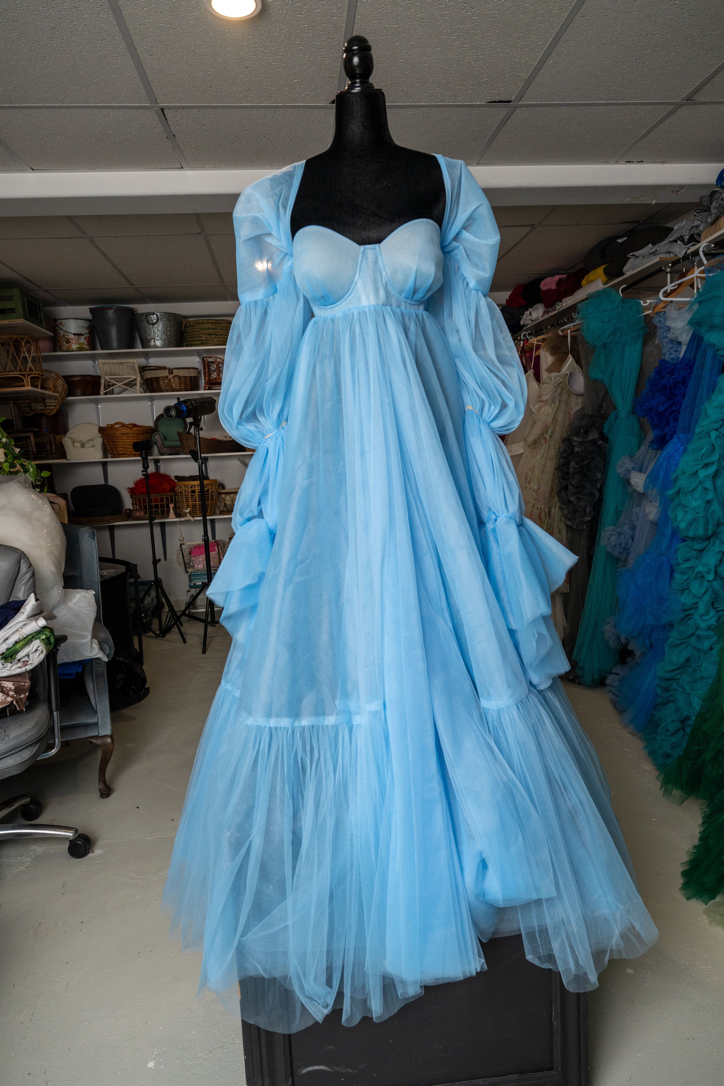 Light blue tulle baby doll dress with puff sleeves displayed on mannequin in clothing studio.