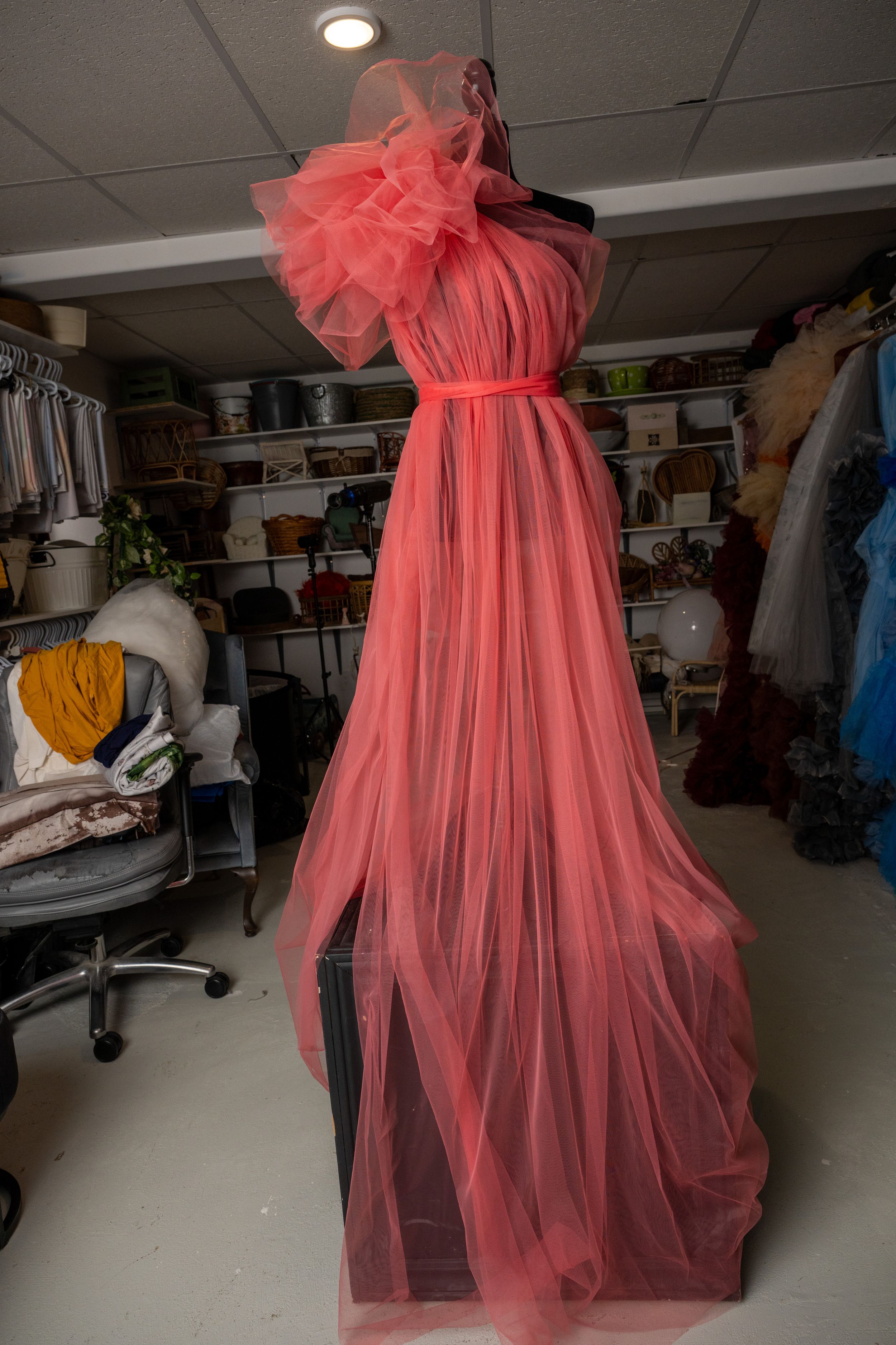 A series of photos showing a pink tulle dress being constructed in a fashion workshop or studio space.