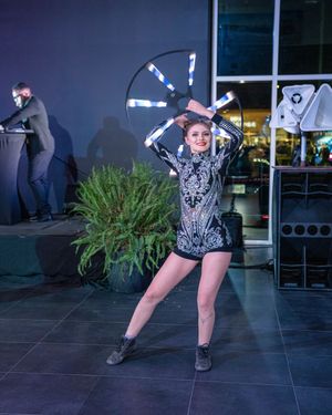 A dancer in a black sequined outfit performs dynamic poses in a series of five connected photos against a dark background.