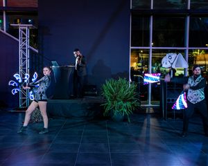 Entertainment performers in costume on stage with lighting and technical equipment.