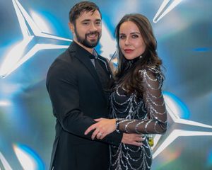 People posing together against a blue background with glowing white lines creating a dynamic effect.