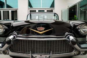 Row of classic black Cadillac cars showcased in a showroom setting.