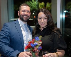 Elegant evening gathering with people enjoying drinks and conversation at a formal event.
