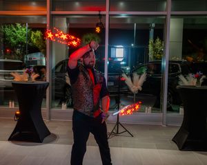Nighttime event venue with red accent lighting and large glass windows displaying performers and equipment.