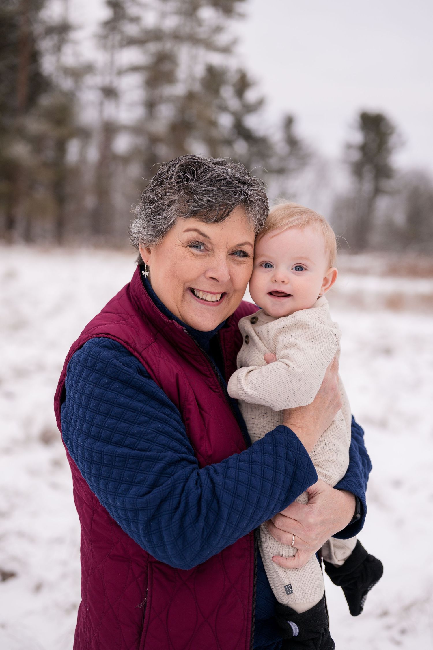Winter outdoor photo shoot in snowy landscape with evergreen trees.