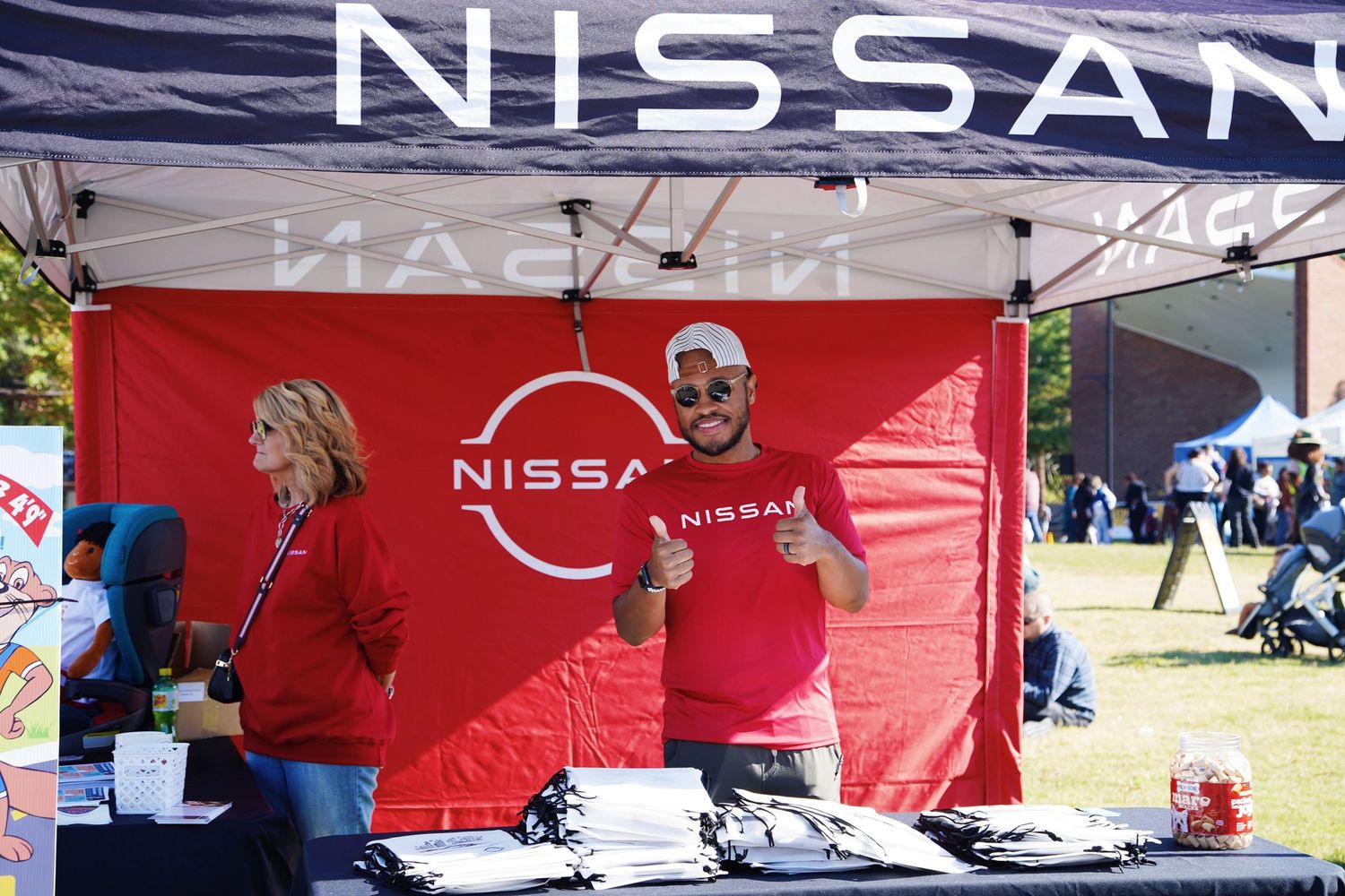 Row of red Nissan branded event tents set up outdoors at promotional event.