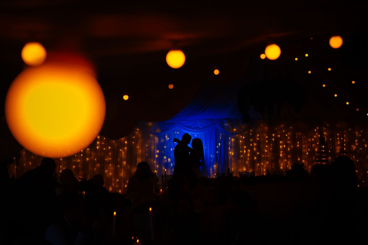 Glowing orange orbs illuminate a dark night sky in a mesmerizing display of lights and reflections.