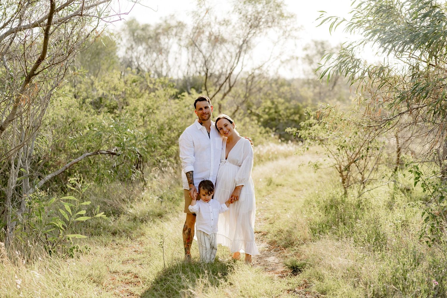 Natural outdoor setting with grassy hills and scattered trees in warm sunlight.