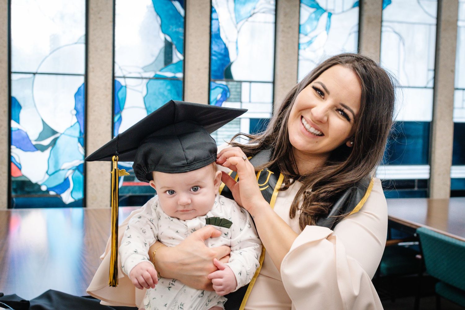 Nursing graduate holding her baby during a graduation photo session in Tacoma Washington