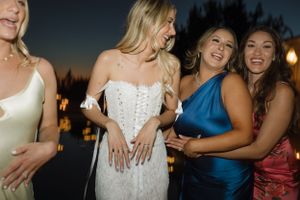 Joyful celebration moment captured between friends at outdoor wedding reception.