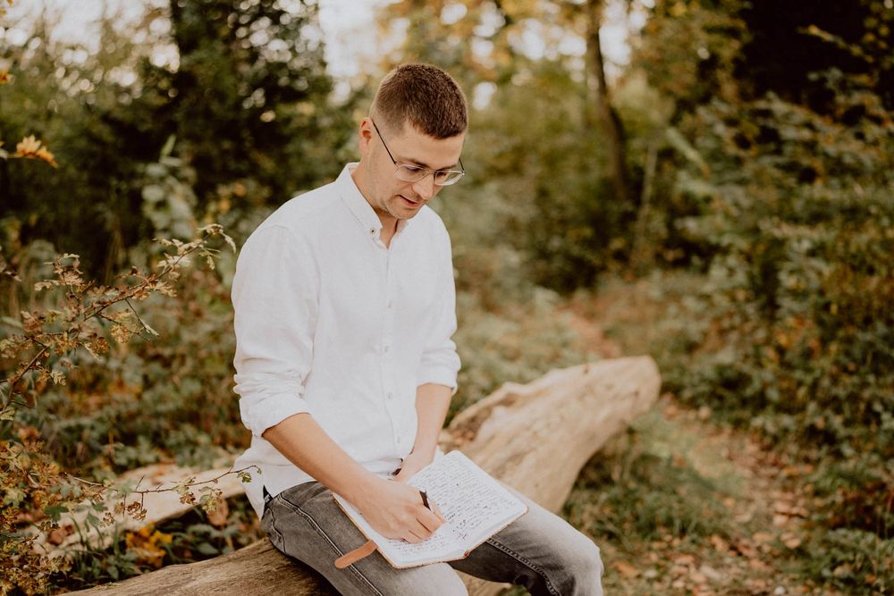 Casual outdoor portrait session on wooden logs during fall season.
