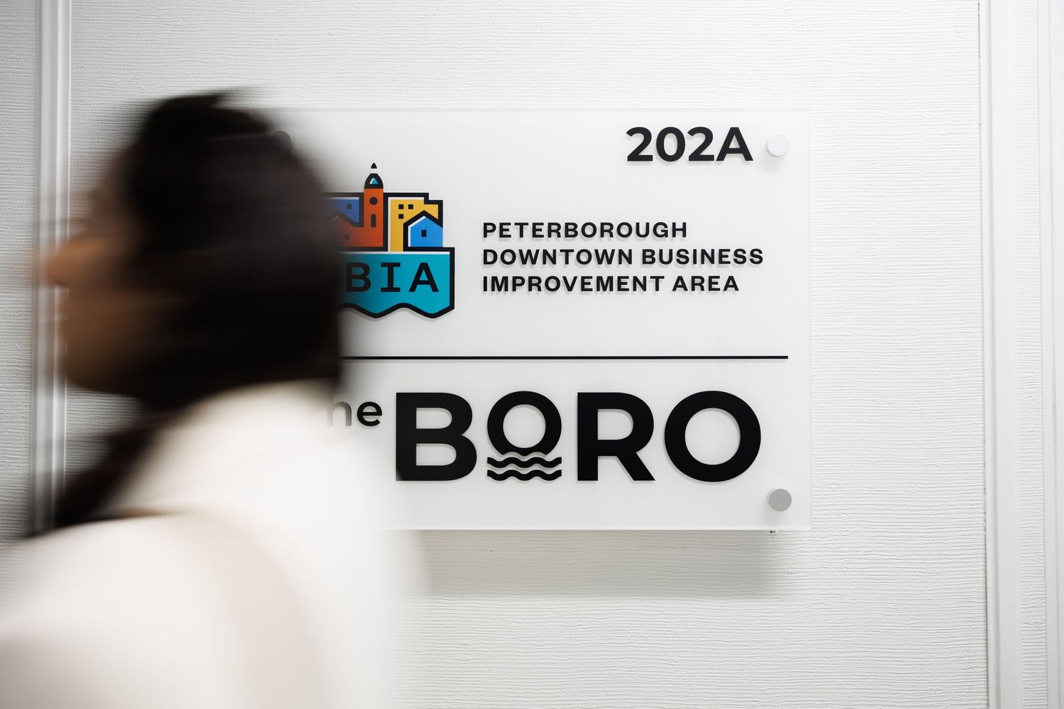 A blurred black and white business sign showing 'The BORO' text with additional text and logos.