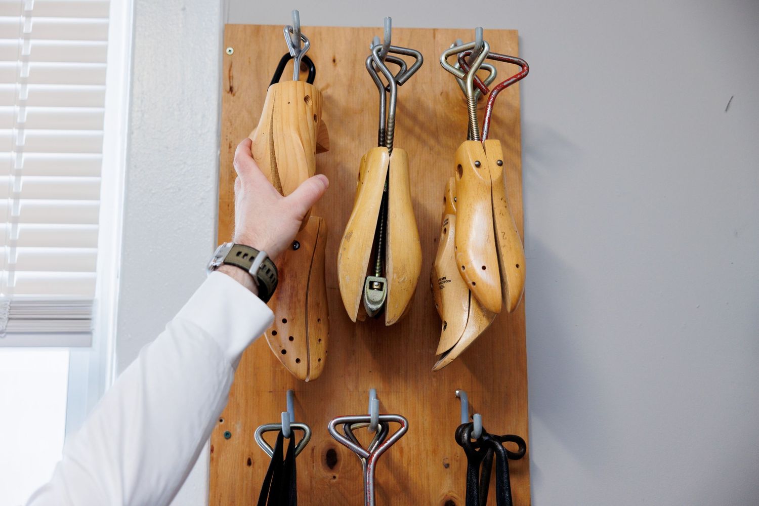 Wooden glove molds mounted on a wall display vintage industrial craftsmanship and design.