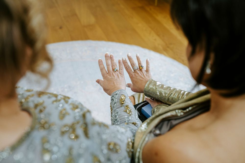 Hands playfully reaching for a flowing white veil during a wedding celebration.