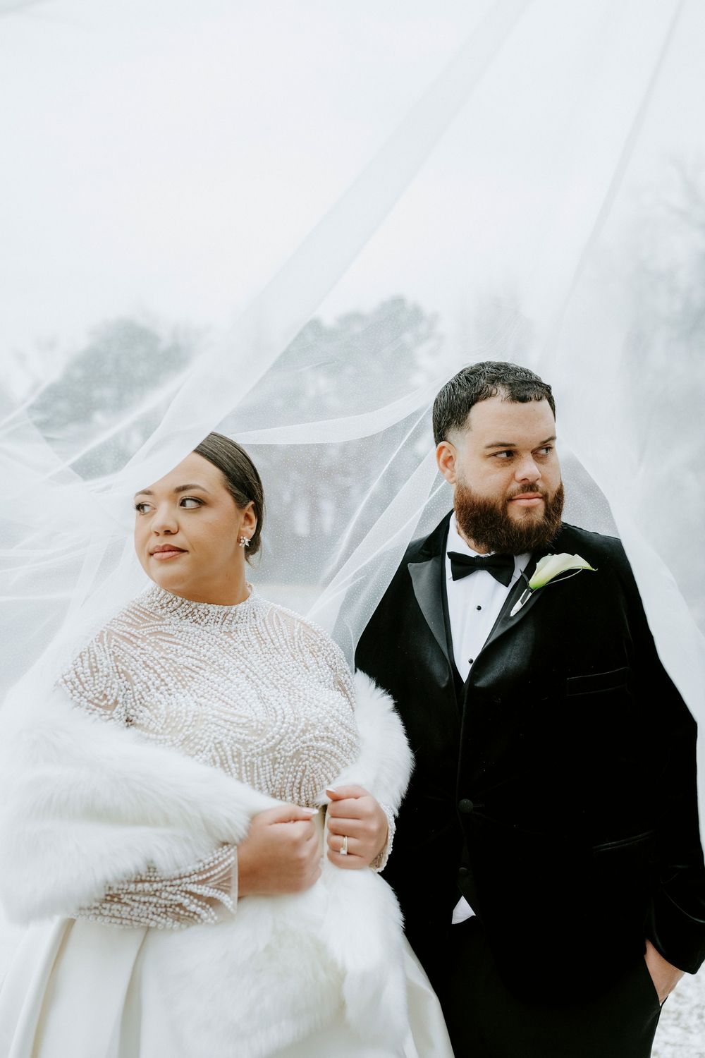 Romantic winter wedding portraits with a bride in beaded gown and groom in classic tuxedo.