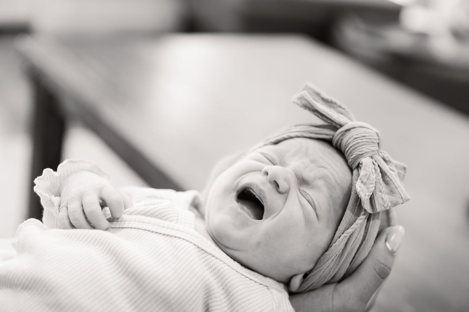 Black and white photo series showing a newborn baby sleeping peacefully in different positions.