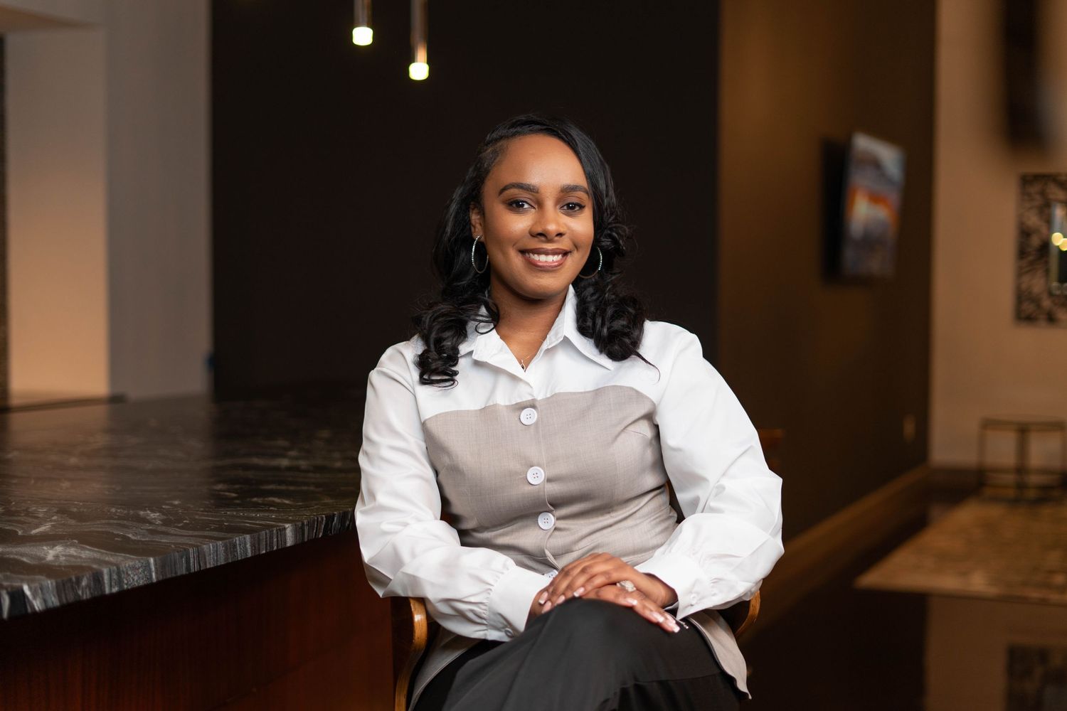female real estate agent sitting, smiling at the camera
