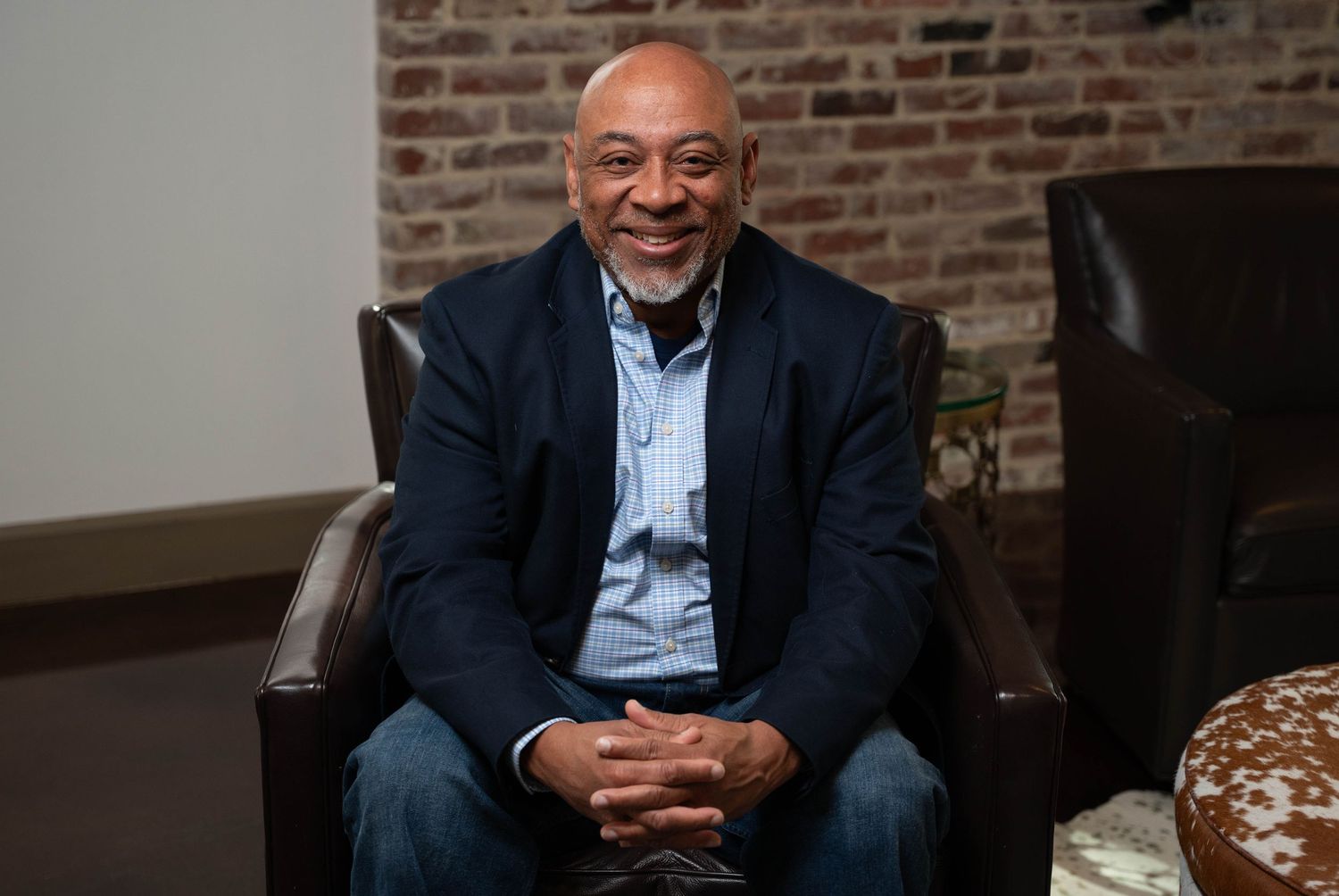 Real estate agent headshot. man sitting in chair smiling at camera