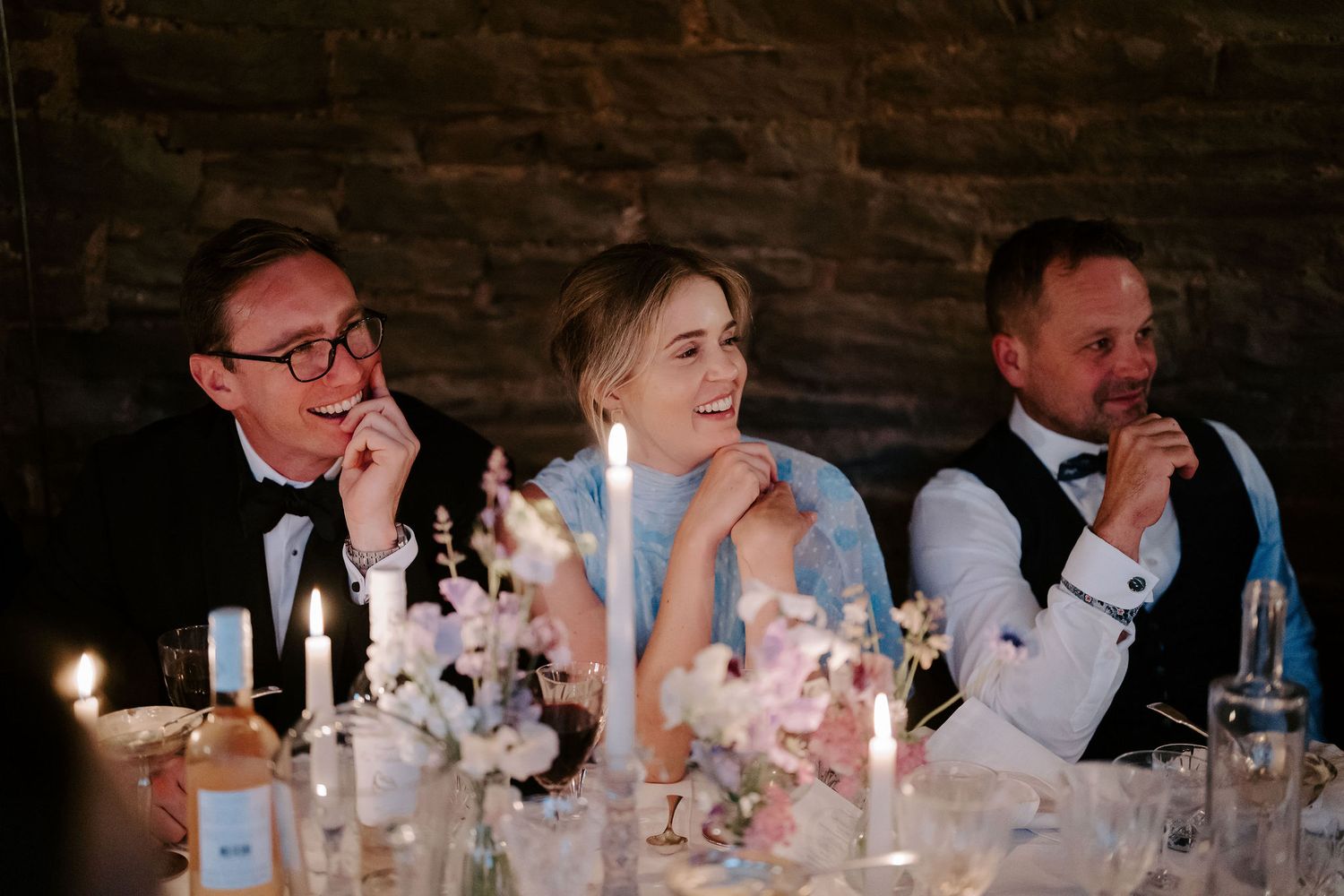 wedding guests smiling at speaker during wedding speeches at dewsall court in herefordshire