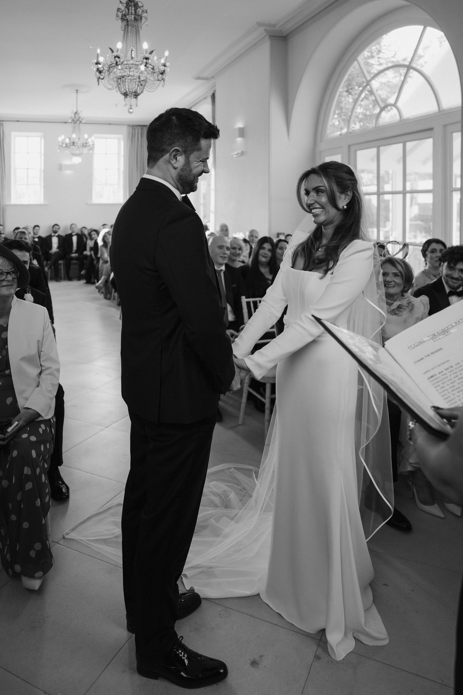 bride and groom holding hands at the alter during the announcement they are husband and wife at Iscoyd park