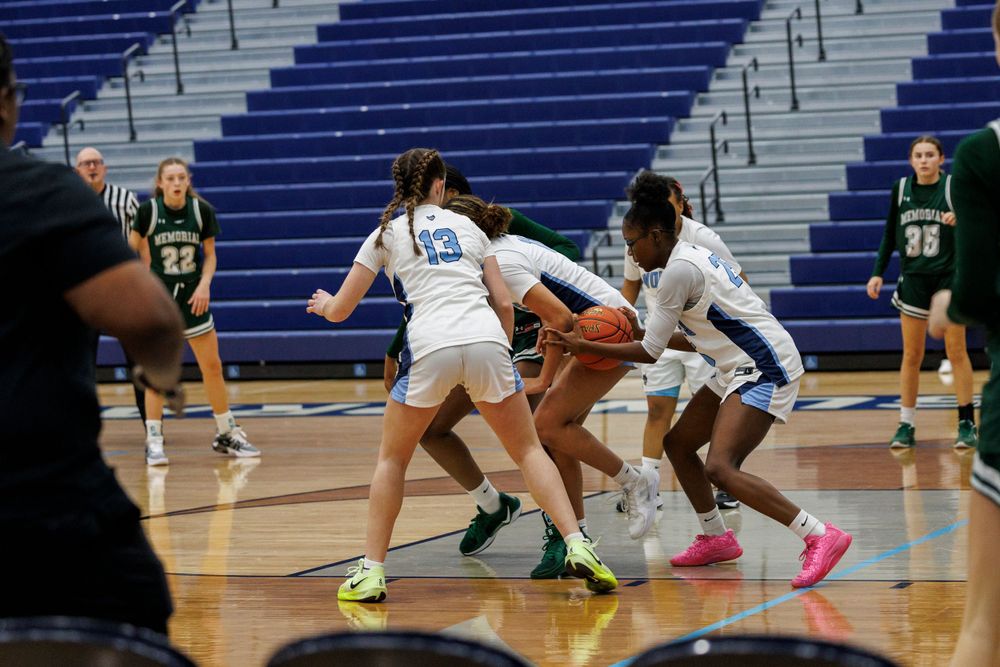 Basketball players battle for possession during intense game action on court.