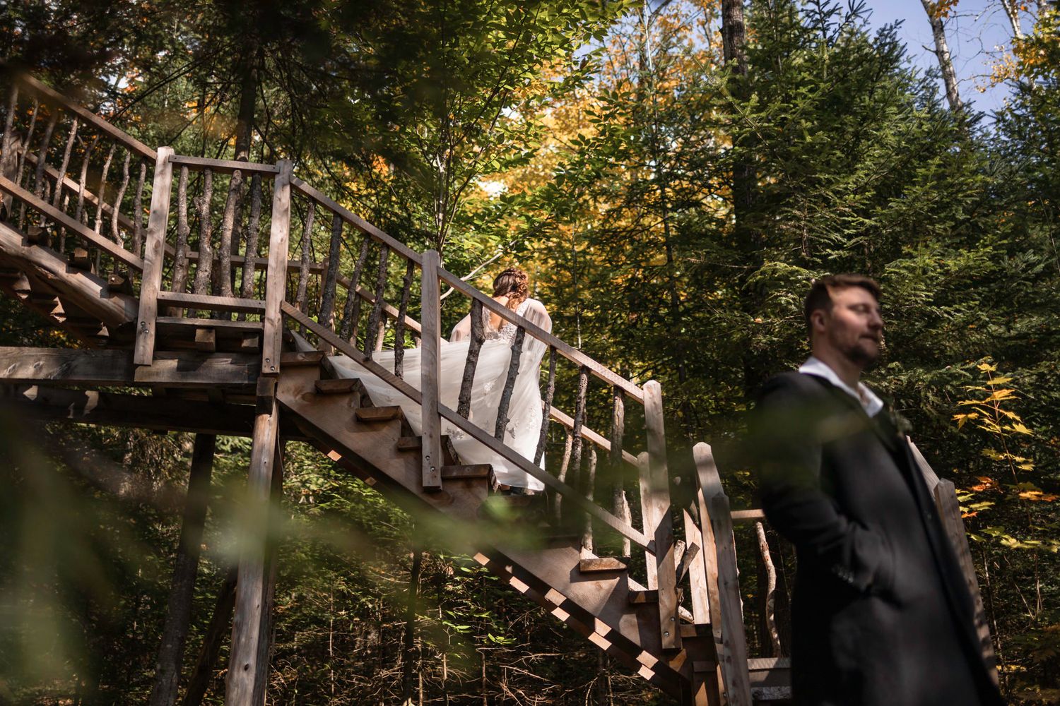 Eloping couple's first look. She comes down the stairs behind her partner in Mont Tremblant, Quebec, Canada.
